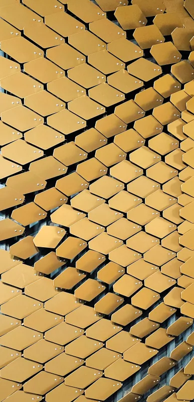 Brass wave shingle façade in diagonal courses